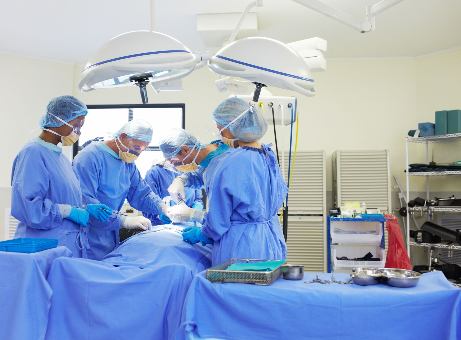 Health professionals perform a procedure on a patient.
